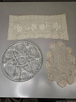 All three items laid out: glass tray, rectangular doily, oval doily