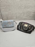 Both handbags side by side on table