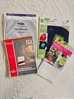 Four packaged items laid out: two carbon paper packs, T-shirt transfer paper pack, pet iron-on kit