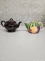 Both teapots side by side for size and style comparison