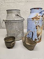 All four items together: galvanized C.N.R. milk can, blue rusted milk can, miniature coal scuttle, small cauldron.