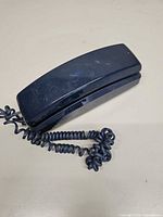 Closed GE blue trimstyle phone with coiled cord visible