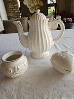 coffee pot, round jar, heart-shaped box grouped on table