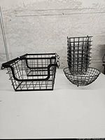 Two under-shelf wire baskets and stacked small/round baskets on table