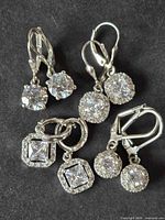 All four pairs of sterling silver CZ earrings on dark background