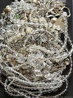 Pile of clear acrylic bead necklaces showing variety of shapes and strands