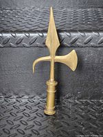 Full view of brass halberd finial standing upright