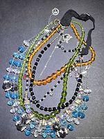 Pile of seven assorted crystal bead necklaces showing full range of colours and chains