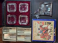 Group shot showing four ashtrays in case, horse paperweight with box, and two boxes containing votive holders