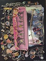 overview of bracelets and loose charms on black background