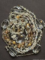 Full view of coiled necklaces showing variety of beads and chains