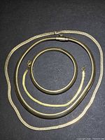 All four gold-filled chains coiled on dark background