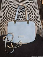 Full view of handbag showing colorblock design, handles, strap