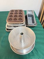 Stack showing 12-cup muffin pan, three 6-cup muffin pans, two loaf pans, tube pan front