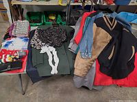 Overview of folded jackets, scarves, wallet, socks on table