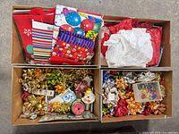 three boxes containing bows, ribbon spools, tissue, gift bags, tags