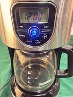 Front view showing stainless panel, LCD display, control pad and glass carafe