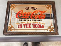 Front view of framed Coca-Cola mirror sign showing full graphic and frame