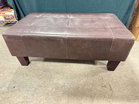 Full view of ottoman front and side showing upholstery and legs