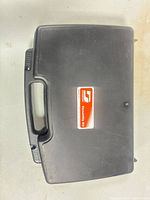 Closed black Dynabrade hard case showing top, handle, label, latch