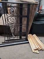 Disassembled bed frame components including headboard, footboard, side rails, and bundle of wood slats