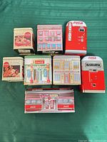 Group shot of eight assorted Coca-Cola tins showing variety of shapes and graphics