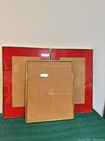 Three gold-tone metal frames with red mats displayed together