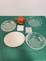 All items arranged on table: teapot, three glass pieces, ceramic platter, two coaster stacks