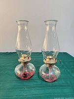 Front view of both hobnail glass kerosene lamps showing bases, burners and chimneys