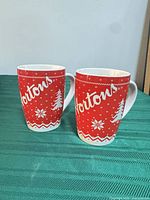 Two Tim Hortons red knit pattern ceramic mugs front view