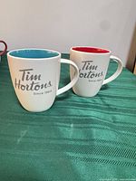 Front view of both Tim Hortons mugs showing logo and exterior colors
