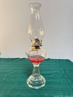 Full view of glass oil lamp with chimney and brass burner