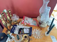 Overall lot showing brass candlesticks, oil lamps, crystal holders, boxed candles and loose tapers