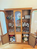 Full view of oak china cabinet hutch with doors open showing glass shelves and lower storage