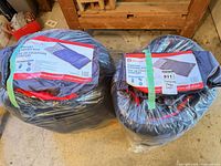 Both sleeping bags in their stuff sacks with labels visible