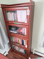 Full view of mahogany display cabinet front, showing four glass doors and brushed nickel knobs