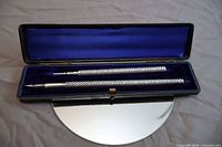 Pencil and pen inside open blue velvet case