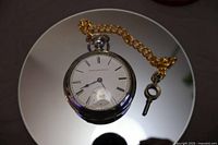 Front view of Elgin pocket watch with chain and key