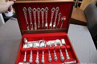 Open flatware chest displaying knives, spoons, forks and serving pieces