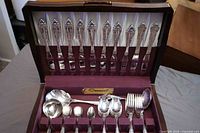 Open case showing full set of flatware and serving pieces
