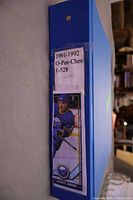 Blue binder spine labelled "1991-1992 O-Pee-Chee 1-528 complete" with Benoit Hogue card