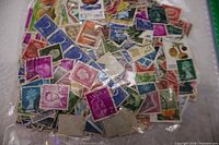 overview of full bag showing numerous colourful used stamps