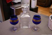 Crystal decanter centered between two cobalt blue wine glasses