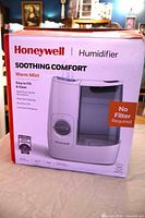 Front of box showing Honeywell Soothing Comfort Warm Mist Humidifier imagery and features