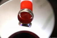 Wide band silver ring top view on red stand