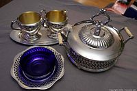 Group view of all silverplate pieces and cobalt dish