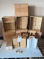 Stacked open cartons showing multiple inner boxes of figurines plus loose boxed units and one unboxed figurine on table