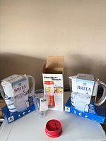 Overall lot showing two Brita pitchers in boxes, Hamilton Beach blender box, jar, red lid