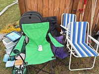 Group shot of folding camp chairs, sling chairs, cooler, freezer packs and picnic backpack