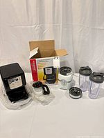 Overall lot showing coffee maker, carafe, blender base, cups and accessories